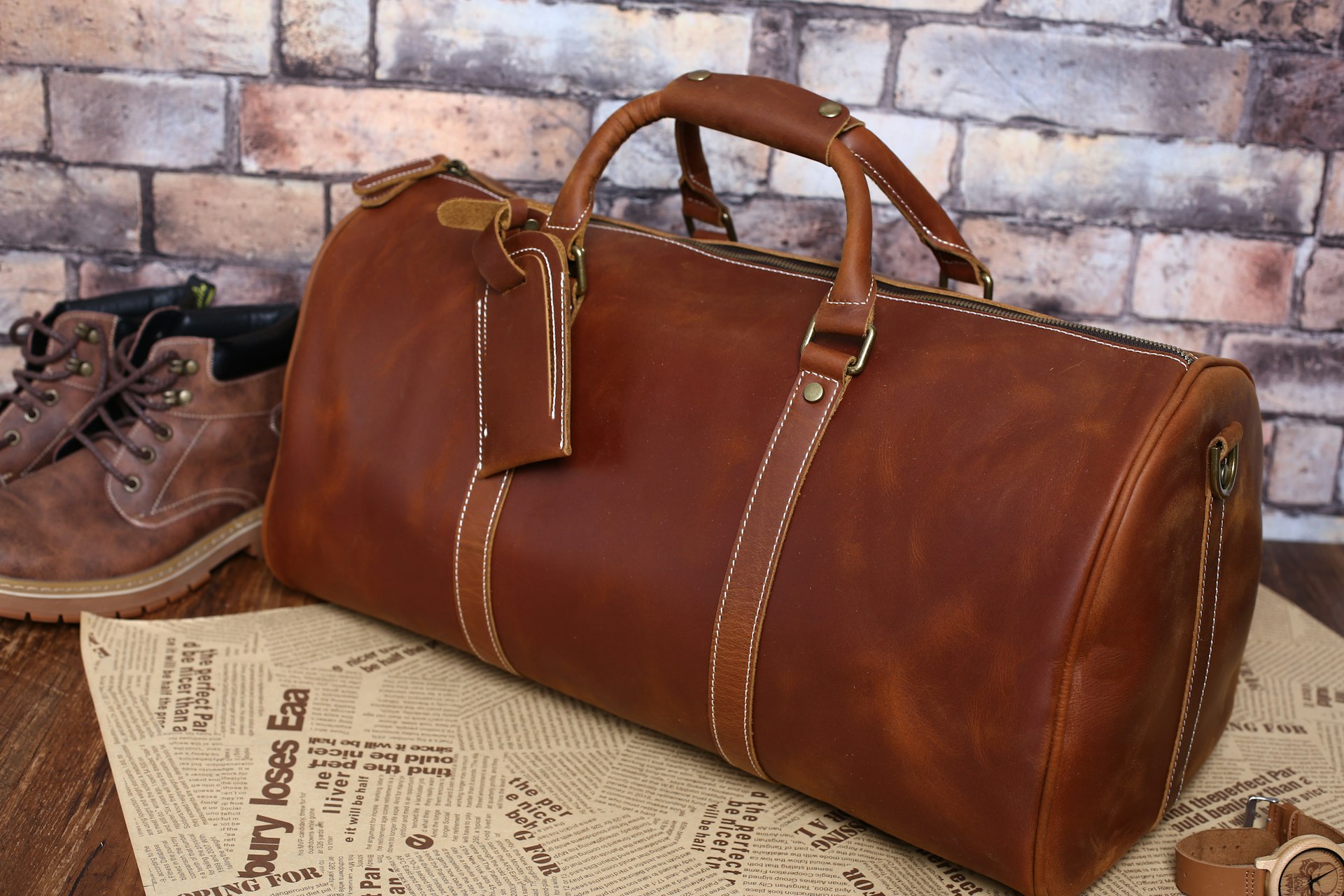 a brown leather duffel bag sitting on top of a table
